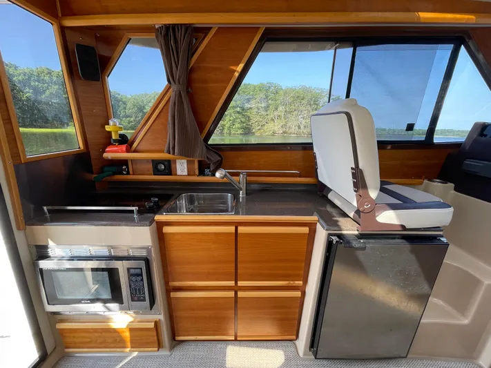  Yacht Photos Pics 2017 Cutwater C-28 boat interior with kitchenette, featuring sink, microwave, and seating.