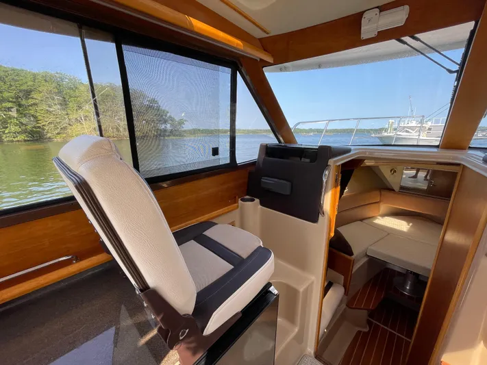  Yacht Photos Pics 2017 Cutwater C-28 boat interior with helm seat, cabin view, and scenic water backdrop.