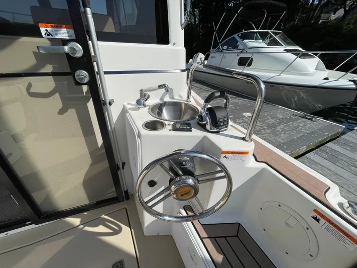  Yacht Photos Pics 2017 Cutwater C-28 boat helm with steering wheel, sink, and controls at dock.