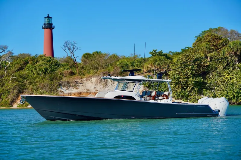 Rhyde Yacht Photos Pics 2021 Valhalla Boatworks V46 cruising near a lighthouse, surrounded by lush greenery.