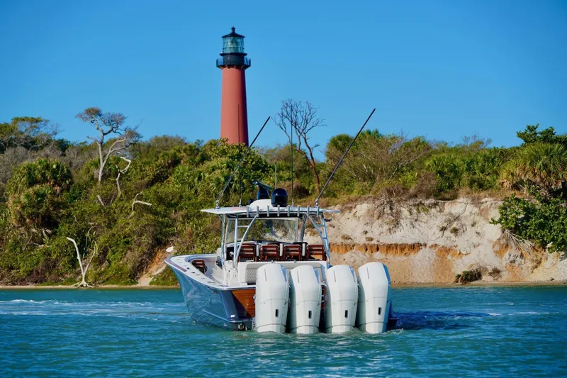 Rhyde Yacht Photos Pics 2021 Valhalla Boatworks V46 cruising near a lighthouse with lush greenery.