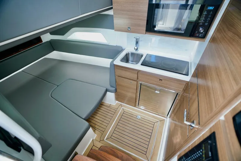 Rhyde Yacht Photos Pics 2021 Valhalla V46 boat interior with kitchenette, seating, and modern wood finish.