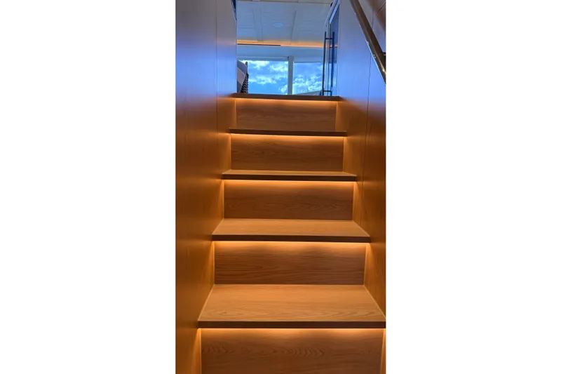 Paso Doble Yacht Photos Pics Illuminated wooden stairs inside a 2025 Granocean W72 yacht, leading to a bright upper deck.