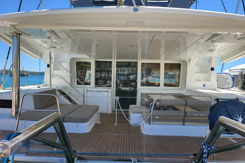 Kuala Yacht Photos Pics Luxurious 2015 Lagoon 52 yacht deck with seating, docked by the sea.