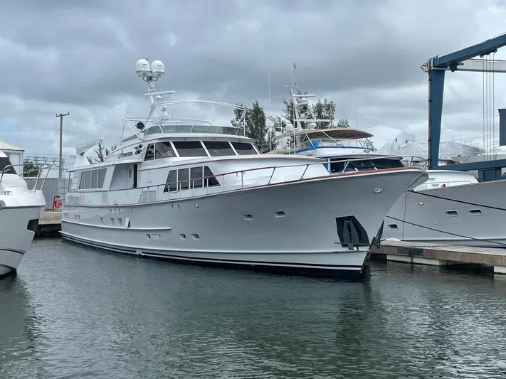Adventurer Yacht Photos Pics Luxury yacht docked at marina, Burger 94 model, 1985, under cloudy skies.
