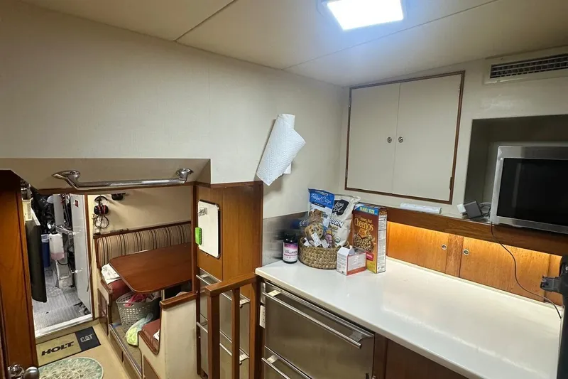Adventurer Yacht Photos Pics Cozy yacht kitchen interior with snacks, microwave, and dining area, Burger 94 model, 1985.