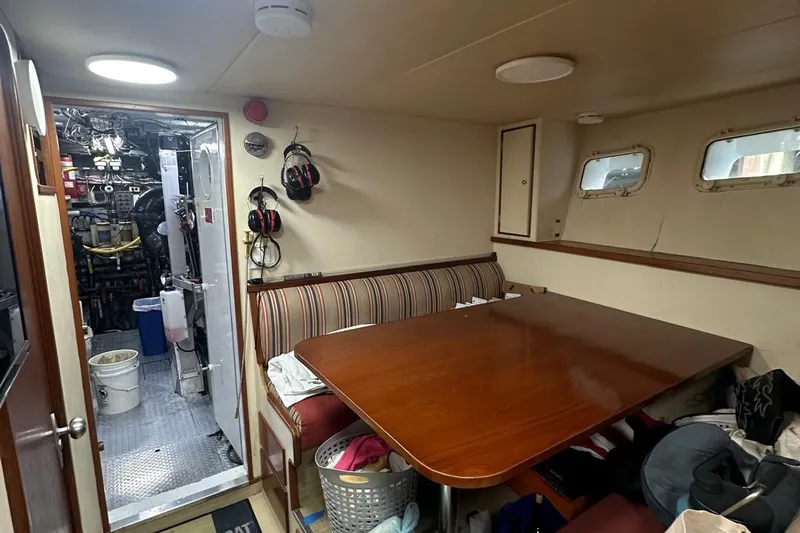 Adventurer Yacht Photos Pics Interior of a 1985 Burger 94 yacht with dining area and engine room access.