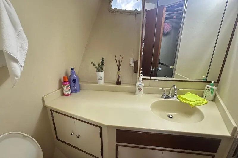 Adventurer Yacht Photos Pics Bathroom vanity with sink, toiletries, and mirror in a 1985 Burger model 94.