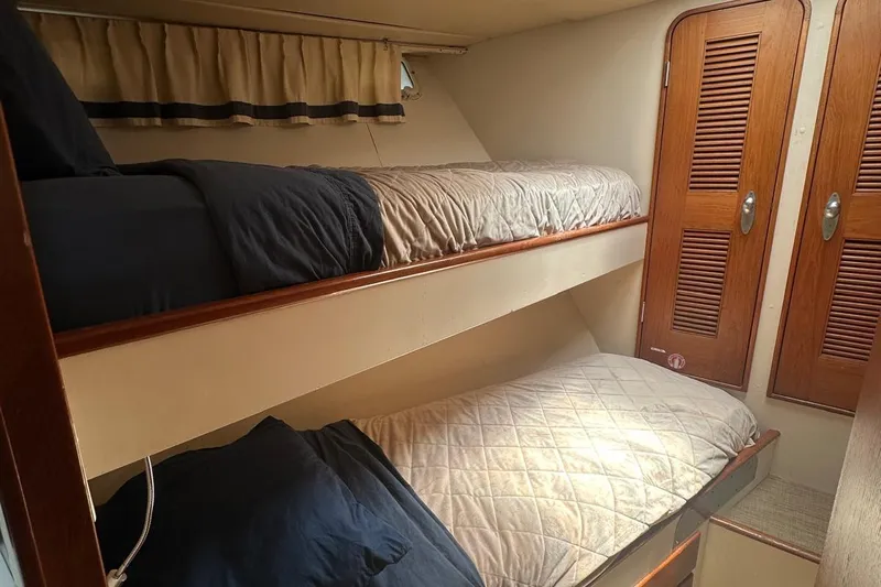 Adventurer Yacht Photos Pics Bunk beds in a 1985 Burger 94 yacht cabin with wooden doors and curtains.