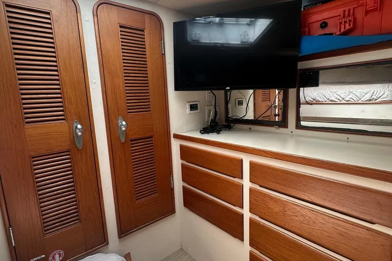 Adventurer Yacht Photos Pics Interior of 1985 Burger 94 yacht with wooden cabinets and mounted TV.