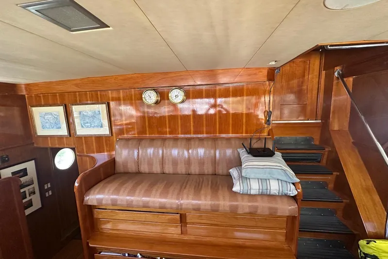 Adventurer Yacht Photos Pics Interior of a 1985 Burger 94 yacht with wooden paneling and cushioned seating.