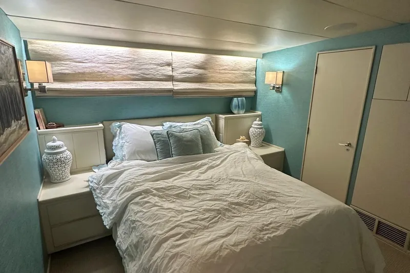 Adventurer Yacht Photos Pics Cozy bedroom with blue walls, elegant decor, and soft lighting on a 1985 Burger model 94.