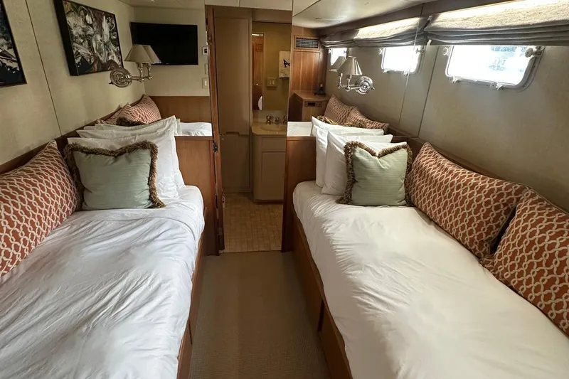 Adventurer Yacht Photos Pics Luxurious twin cabin interior on a 1985 Burger 94 yacht, featuring elegant bedding and decor.