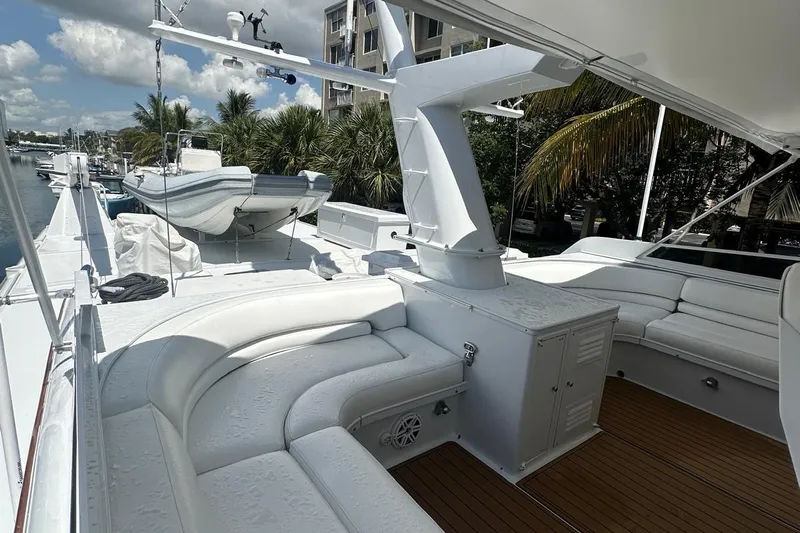 Adventurer Yacht Photos Pics Luxurious 1985 Burger 94 yacht deck with seating and tender, docked near palm trees.