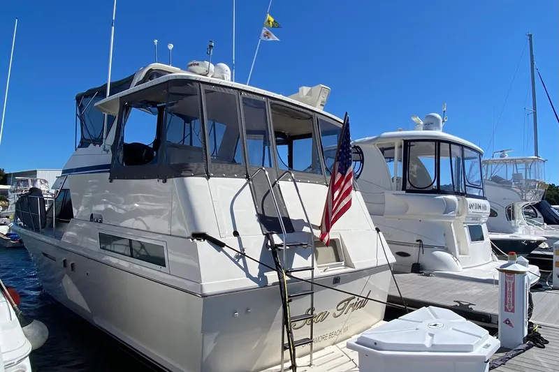 Sea Trial Yacht Photos Pics 1991 Hatteras 40 Motor Yacht docked, featuring American flag and clear blue sky.