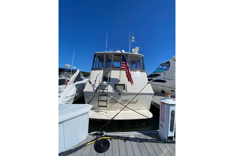 Sea Trial Yacht Photos Pics 1991 Hatteras 40 Motor Yacht docked, displaying American flag under clear blue sky.