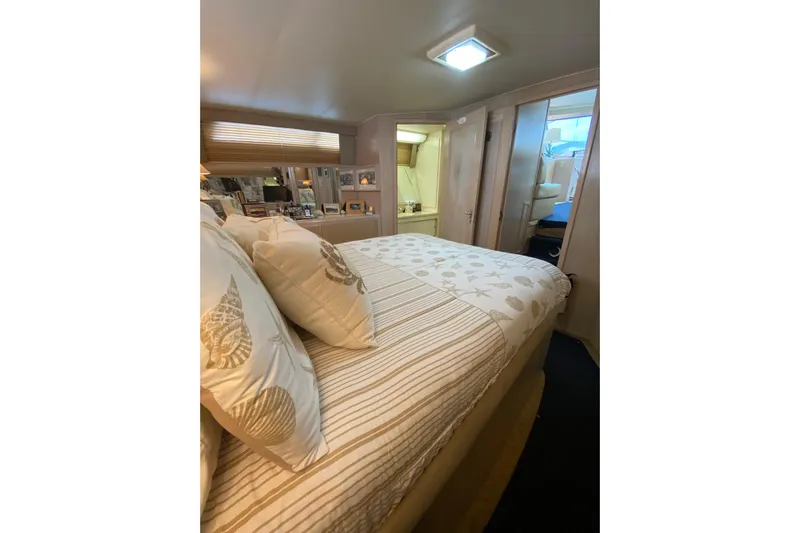 Sea Trial Yacht Photos Pics Cozy bedroom interior of 1991 Hatteras 40 Motor Yacht with nautical-themed bedding.