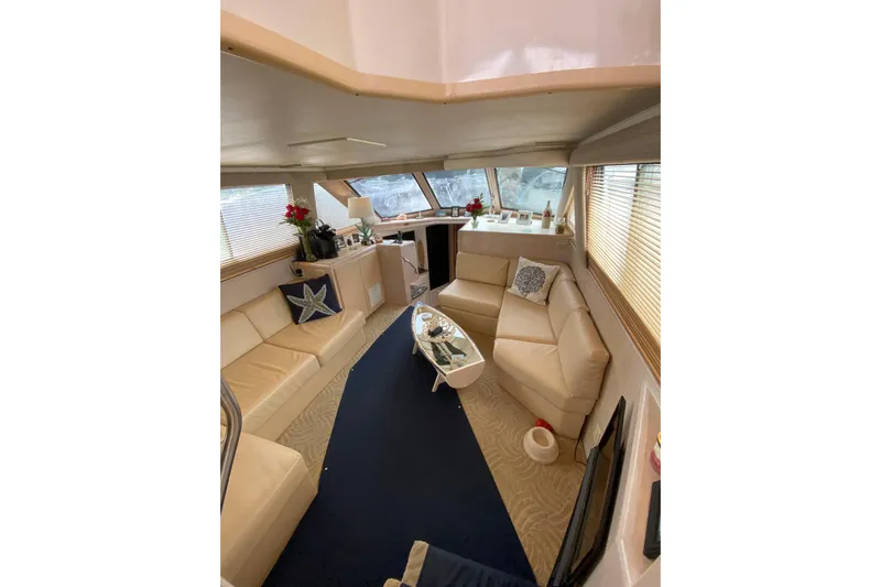 Sea Trial Yacht Photos Pics Luxurious interior of a 1991 Hatteras 40 Motor Yacht with beige seating and nautical decor.