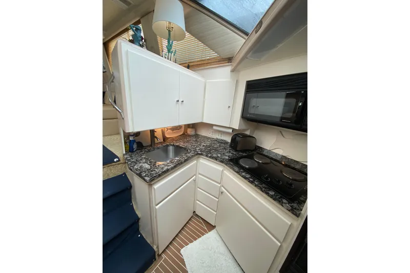 Sea Trial Yacht Photos Pics Compact kitchen in 1991 Hatteras 40 Motor Yacht with granite countertops and modern appliances.