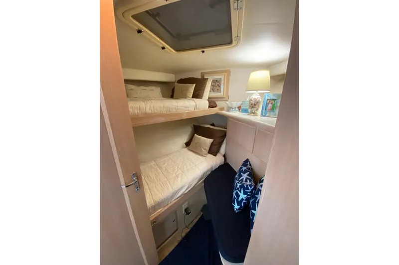 Sea Trial Yacht Photos Pics Interior of 1991 Hatteras 40 Motor Yacht with cozy bunk beds and decorative pillows.
