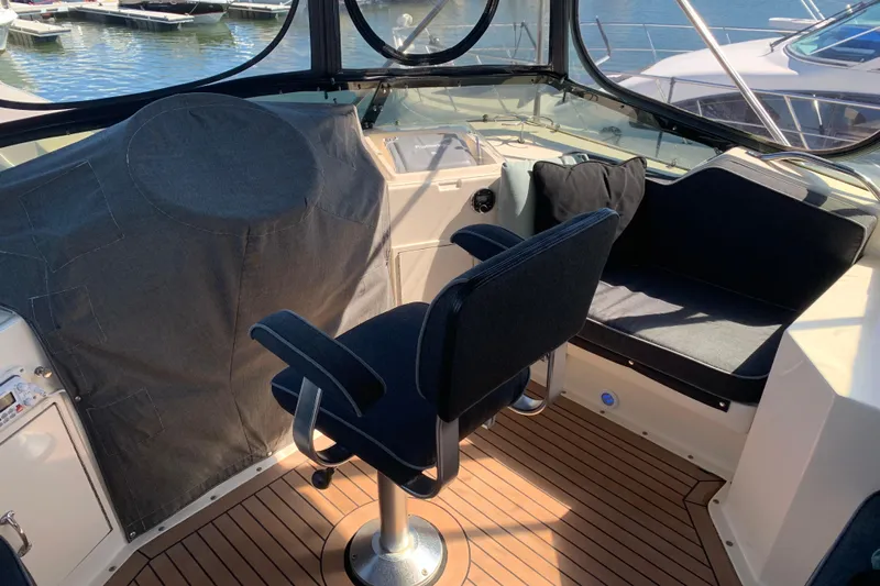 Sea Trial Yacht Photos Pics 1991 Hatteras 40 Motor Yacht helm with seating, covered controls, and marina view.