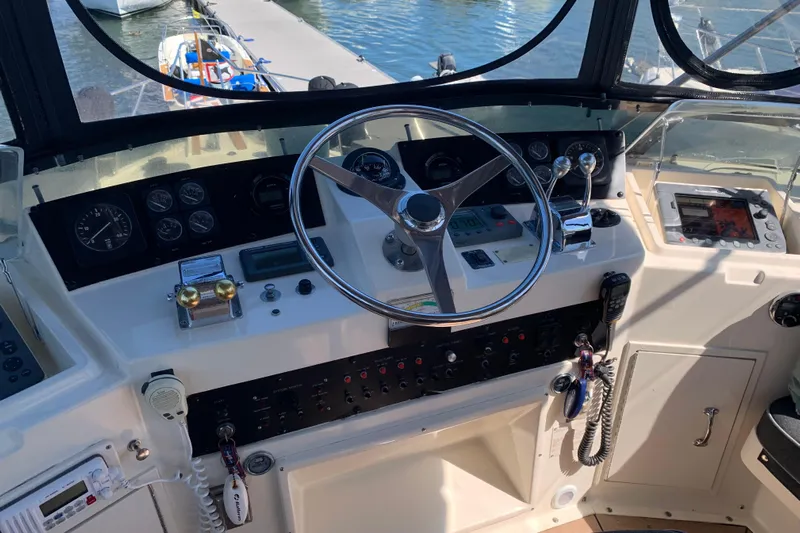 Sea Trial Yacht Photos Pics Control panel of a 1991 Hatteras 40 Motor Yacht with steering wheel and navigation instruments.