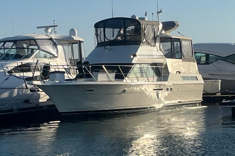 Sea Trial Yacht Photos Pics 1991 Hatteras 40 Motor Yacht docked in marina, reflecting sunlight on water.