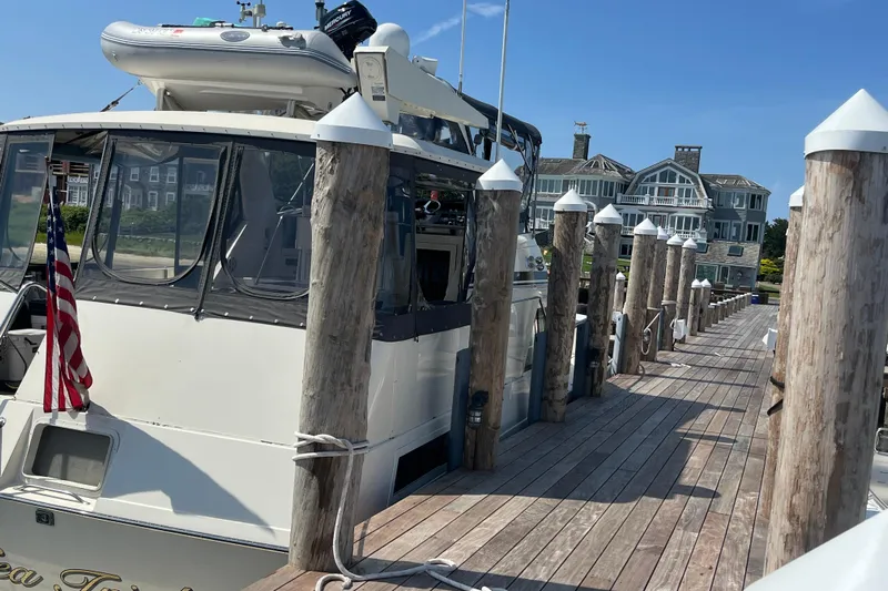 Sea Trial Yacht Photos Pics 1991 Hatteras 40 Motor Yacht docked at a marina with wooden posts and waterfront homes.