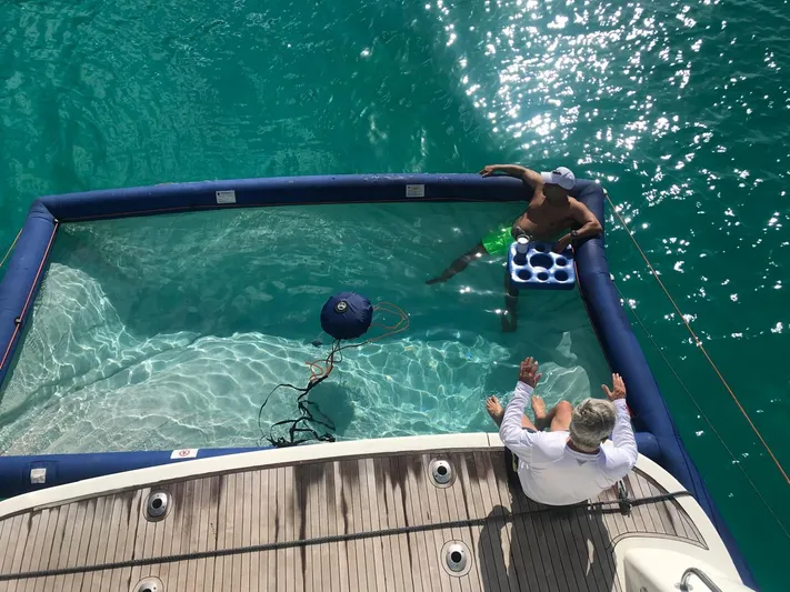  Yacht Photos Pics Two people relaxing on a 1999 Azimut 58 yacht with a floating pool.