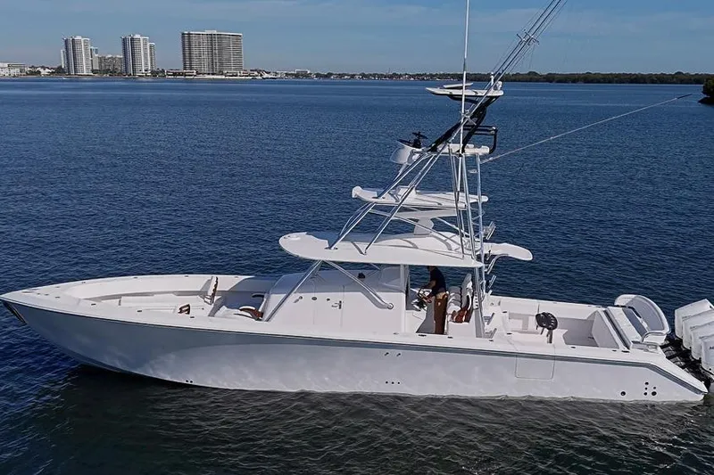  Yacht Photos Pics 2025 Sparks 46 boat on calm water with city skyline in background.