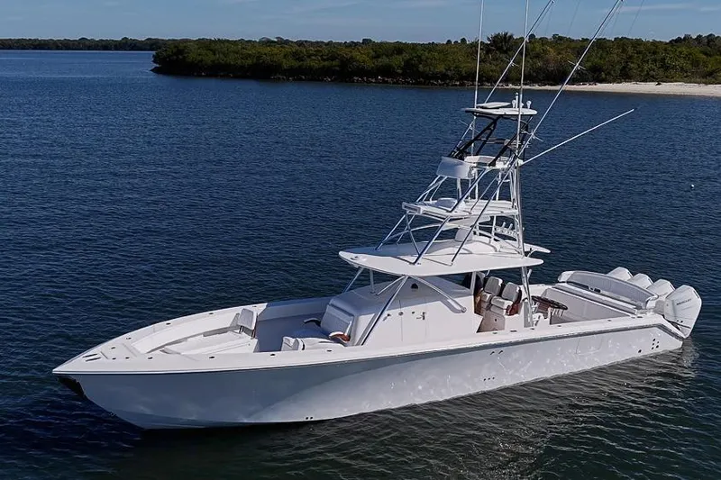  Yacht Photos Pics 2025 Sparks 46 boat on calm water near a lush shoreline.