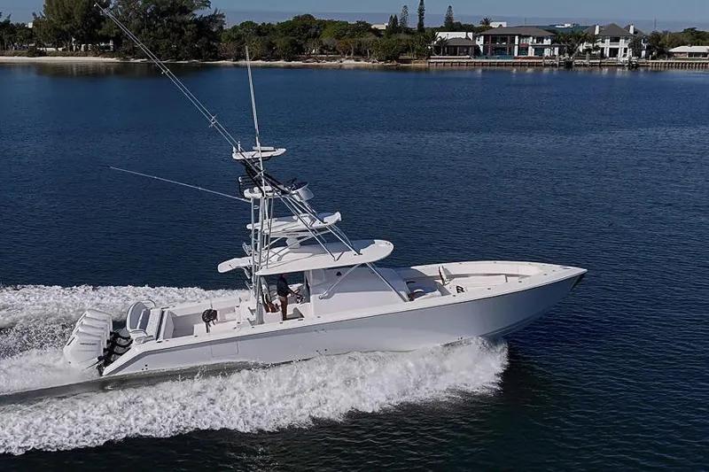  Yacht Photos Pics A 2025 Sparks 46 boat cruising on a calm lake near a residential shoreline.