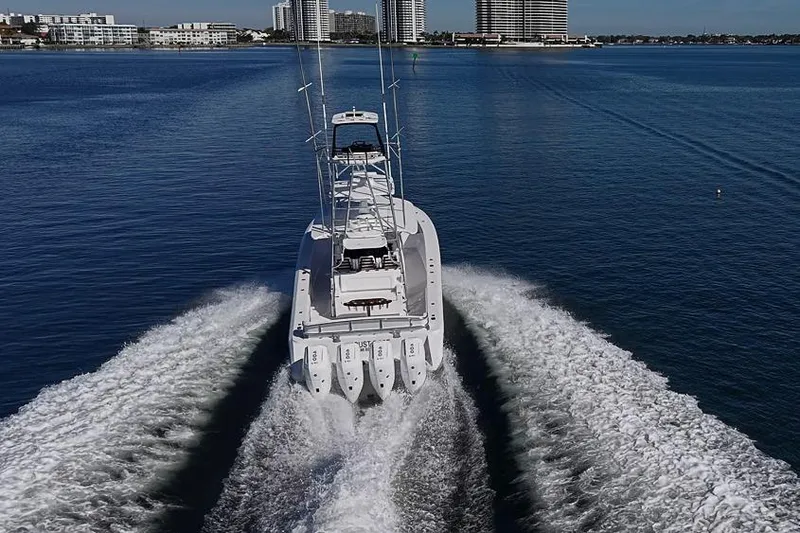  Yacht Photos Pics Sparks 46 boat cruising on water, 2025 model, with city skyline in background.