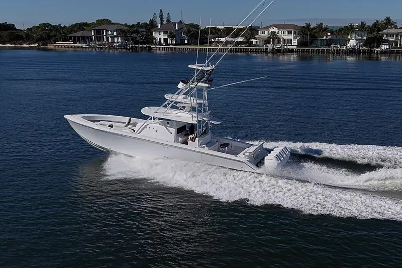  Yacht Photos Pics A 2025 Sparks 46 boat cruising on a calm waterway near waterfront homes.