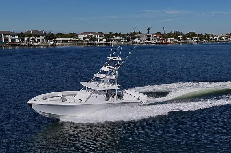  Yacht Photos Pics A 2025 Sparks 46 boat cruising on a calm blue waterway near waterfront homes.
