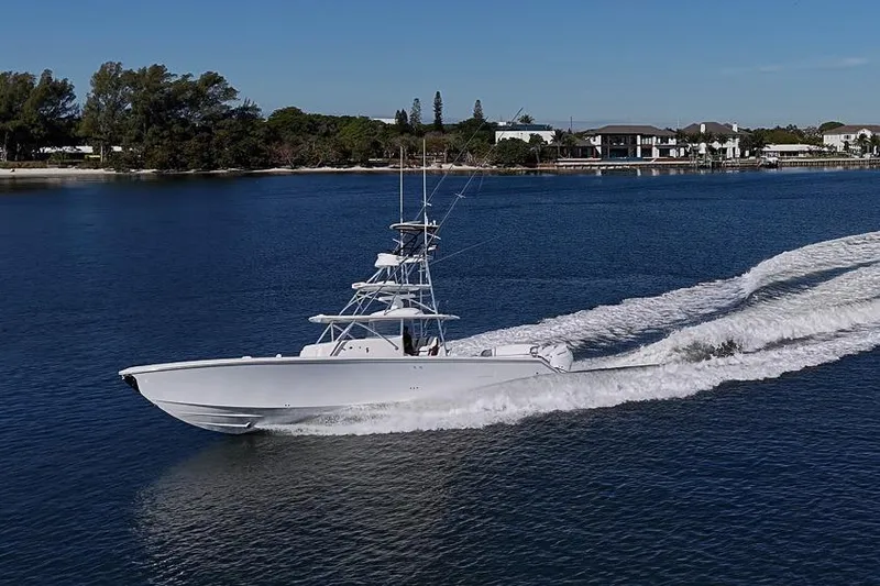  Yacht Photos Pics A 2025 Sparks 46 boat cruising on a serene waterway near a coastal town.