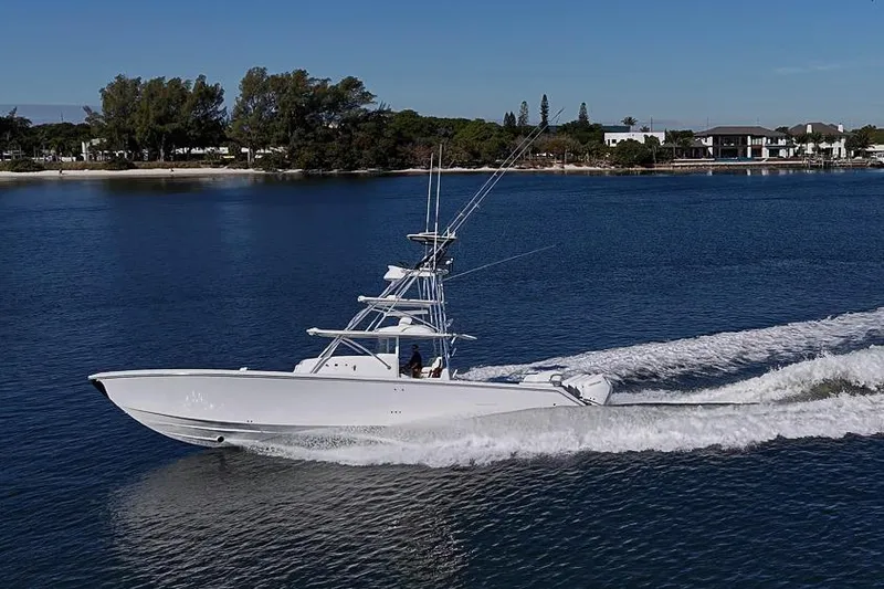  Yacht Photos Pics 2025 Sparks 46 boat cruising on a serene lake with a scenic shoreline.