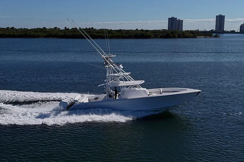  Yacht Photos Pics A sleek 2025 Sparks 46 yacht cruising on a calm blue sea near a cityscape.