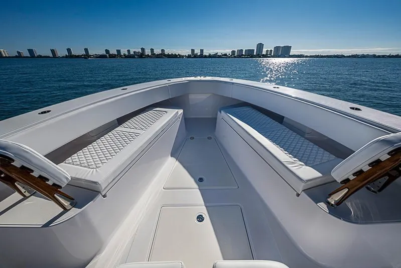  Yacht Photos Pics Luxurious 2025 Sparks 46 boat interior with cushioned seating, overlooking a city skyline on the water.