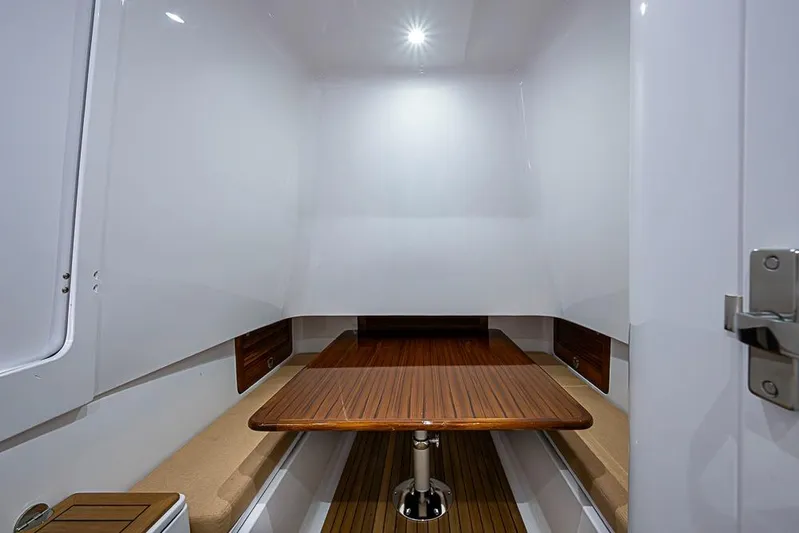 Yacht Photos Pics Interior of 2025 Sparks 46 boat with wooden table and seating.