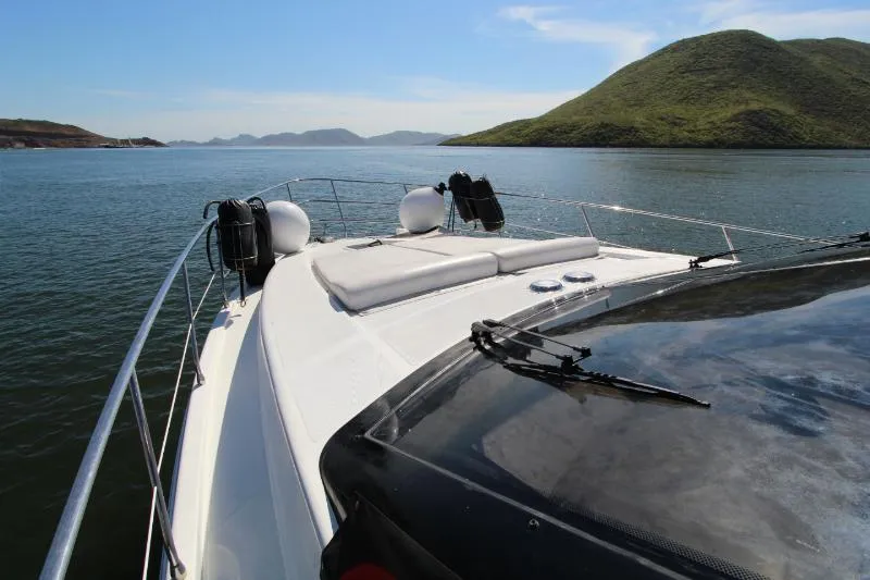  Yacht Photos Pics 1999 Azimut 58 yacht cruising on serene waters with scenic hills in the background.