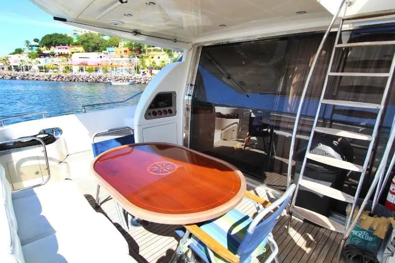  Yacht Photos Pics 1999 Azimut 58 yacht deck with wooden table, chairs, and ocean view.
