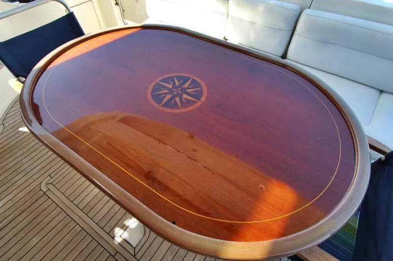  Yacht Photos Pics Luxurious wooden table on 1999 Azimut 58 yacht, featuring a compass rose design.