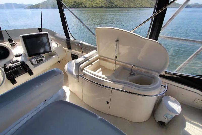  Yacht Photos Pics 1999 Azimut 58 yacht interior with helm, navigation equipment, and open storage compartment.