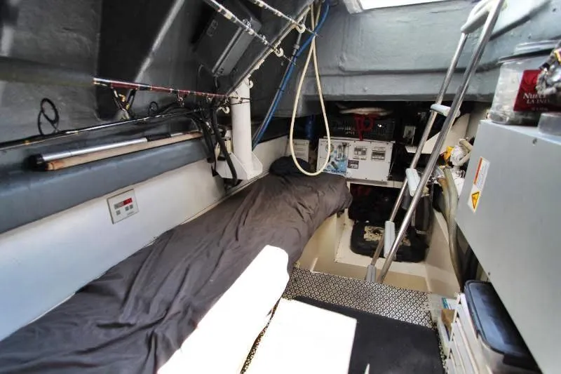  Yacht Photos Pics Interior cabin of a 1999 Azimut 58 yacht with a bed and fishing rods.