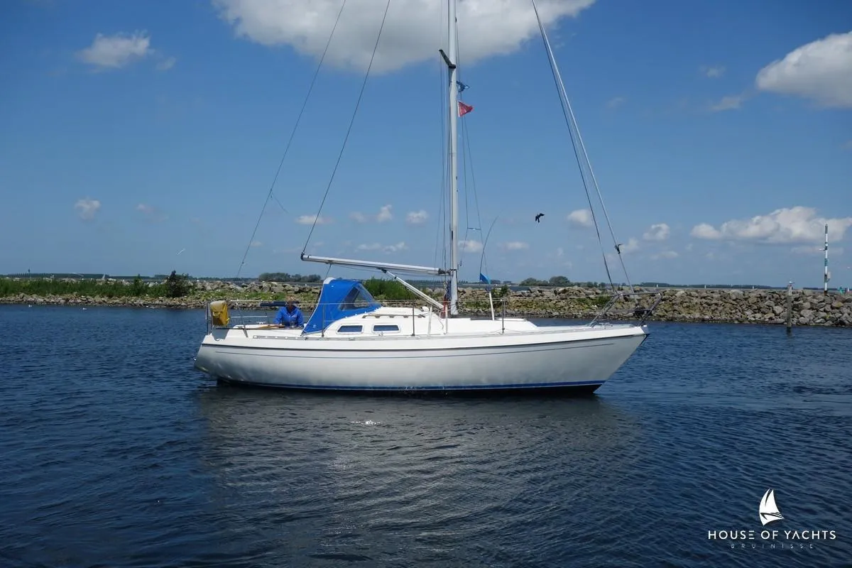 Sailboat Victoire 855, 1990 model, cruising on calm waters under a clear blue sky.