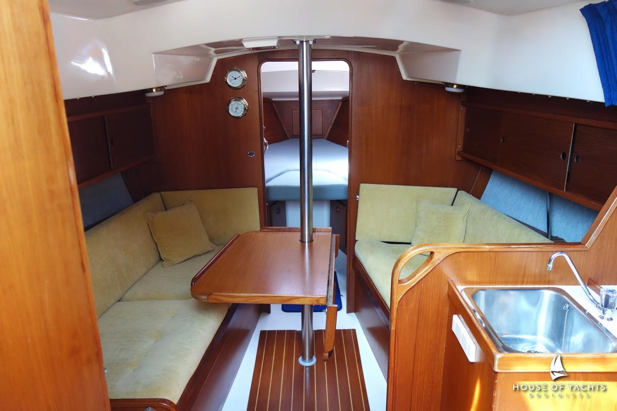 Interior of 1990 Victoire 855 yacht with wooden furnishings and cozy seating area.