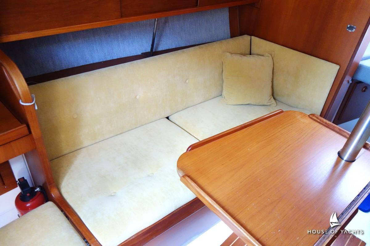 Cozy interior of 1990 Victoire 855 yacht with beige seating and wooden table.