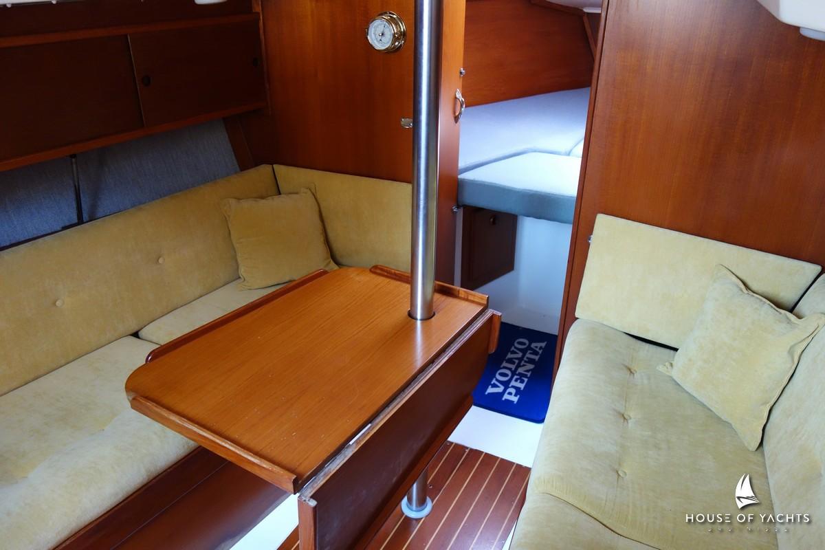 Cozy interior of 1990 Victoire 855 yacht with wooden furnishings and cushioned seating.