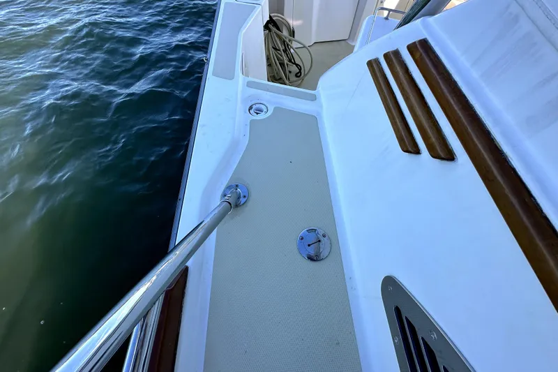 Destiny Yacht Photos Pics 2007 Sabre 34 Express boat deck with railing and wooden accents by the water.